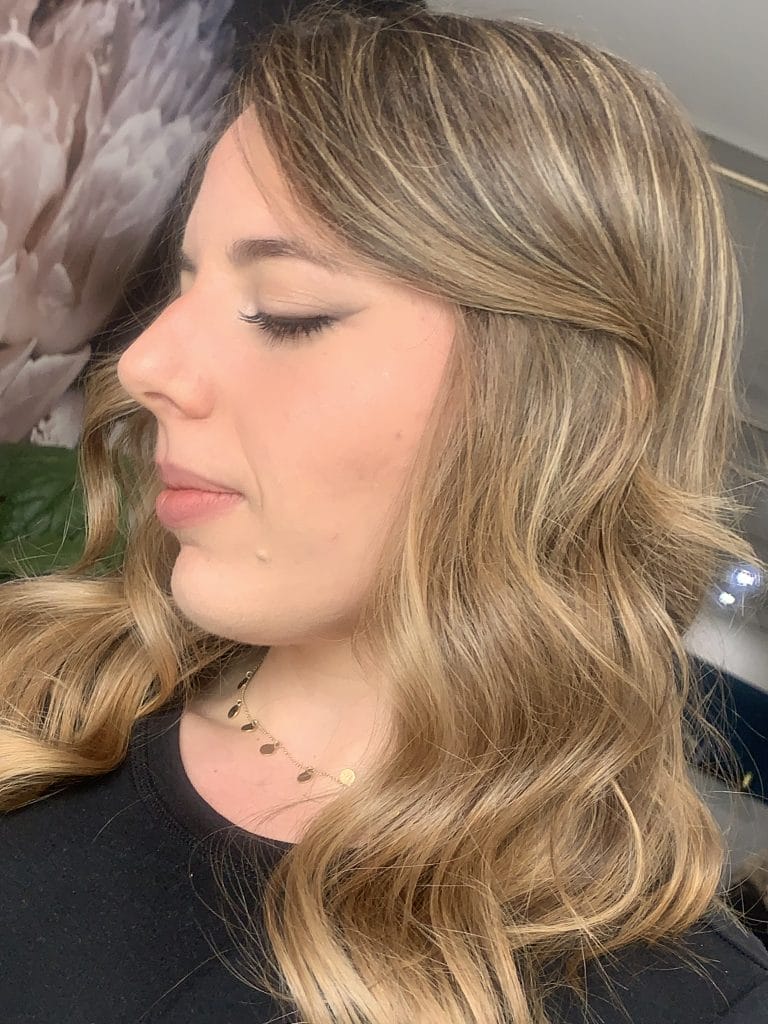 "Transform your hair with this seamless golden blonde color, expertly crafted to make it easier to grow out the color. Located in St Kilda, Melbourne, this hairstyle is finished with a beautifully styled wavy blow dry, adding texture and movement to the hair."