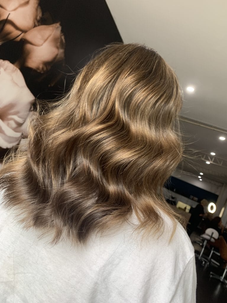 "Experience a winter transformation with this stunning blonde hair color in St Kilda, Melbourne. The biscuit blonde tones perfectly complement the cool winter season, while the expertly crafted highlights add dimension and texture to the hair."